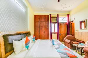 a hotel room with a bed and a chair at FabExpress Royal Ashray in Noida