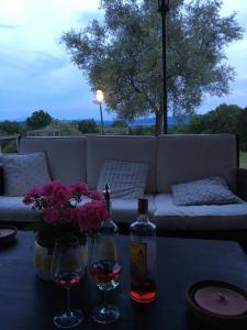 - une table avec deux verres de vin et des fleurs dans l'établissement La Canonica Di San Michele, à Monteriggioni