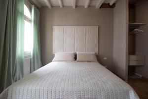 a white bed in a room with a window at Appartamento Delle Vele in Venice