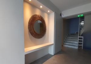 a mirror on a wall in a hallway with stairs at ammos seafront family apartments in Nea Plagia