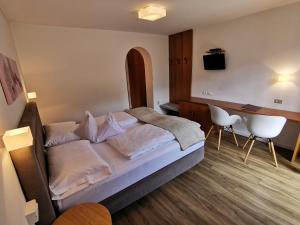 Schlafzimmer mit einem Bett, einem Tisch und Stühlen in der Unterkunft Garni Weghueb in Rabland