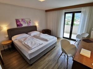 a hotel room with a bed and a balcony at Garni Weghueb in Rablà