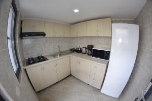 a small kitchen with a sink and a refrigerator at Vila 69 in Costinesti +16 photos