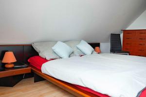 een slaapkamer met een bed met witte lakens en kussens bij Ferienwohnung Krebs in Hooksiel