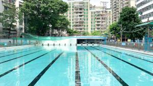 a large swimming pool in a city with tall buildings at Guangzhou Seaman Hotel-Line 2 JiangNanXi Station in Guangzhou