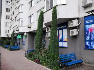 a building with two blue benches in front of it at Просторная квартира на улице Бориса Гмыри 4 in Kyiv