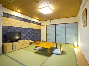a living room with a wooden table and a television at Diamond Kyoto Society in Kyoto