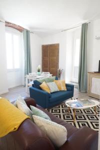 a living room with two blue couches and a table at Appartement Gaudin in Bastia