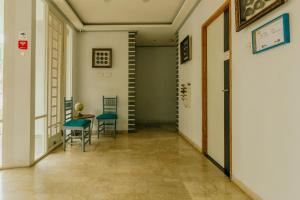 a hallway with chairs and a table and stairs at Urbanest Inn House TB Simatupang in Jakarta