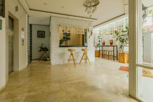a living room with wooden stools and a brick wall at Urbanest Inn House TB Simatupang in Jakarta