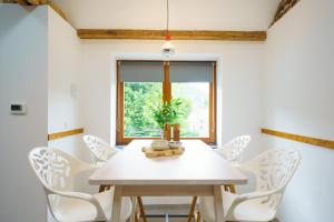 une salle à manger avec une table blanche et des chaises blanches dans l'établissement Appartement Les Bleuets, à La-Roche-en-Ardenne