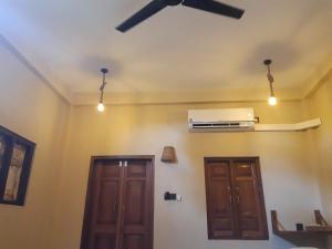 Habitación con 2 puertas y ventilador de techo. en Agro Village Resort , Kalpitiya, en Kalpitiya
