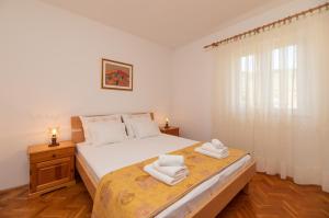 - une chambre avec un lit et 2 serviettes dans l'établissement Apartment Jelica, à Supetar
