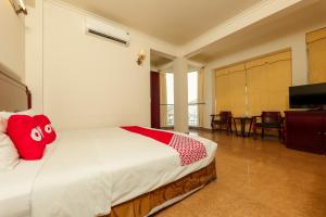 Un dormitorio con una cama con una almohada roja. en Sunlight Hotel Hạ Long, en Ha Long