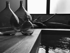 three glass vases sitting on a table next to water at LE MAS DES AUGES in Barjac