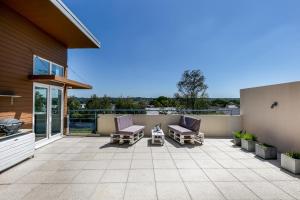 a patio with two lounge chairs and a balcony at L' Évéa Rooftop in Le Relecq-Kerhuon
