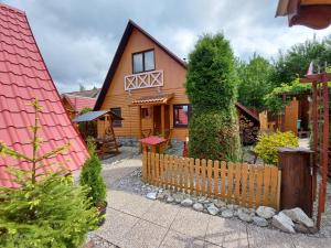 a wooden house with a fence in front of it at Chata Talia in Liptovský Mikuláš