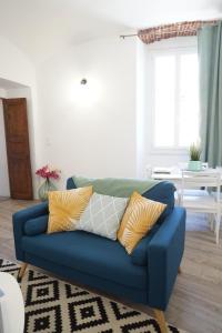 a blue couch with yellow pillows in a living room at Appartement Gaudin in Bastia