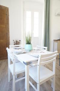 a white table and chairs with a plant on it at Appartement Gaudin in Bastia