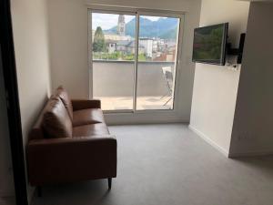 a living room with a couch and a large window at Loft Rêve du Soir 125 m2 climatisé 350 m de la gare in Lourdes