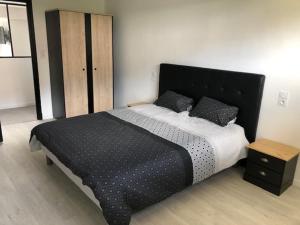 a bedroom with a large bed and a wooden cabinet at Loft Rêve du Soir 125 m2 climatisé 350 m de la gare in Lourdes