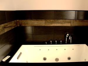 a bathroom with a bath tub with a sink at Appart Hotel Relax Spa in Lens