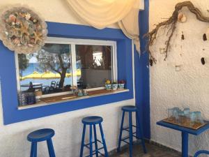 a bar with three stools in front of a window at HOTEL KATERINA in Pythagoreio