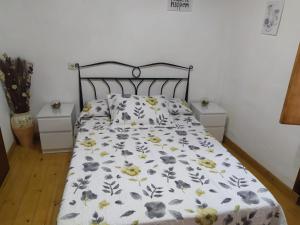 1 cama con edredón de flores y 2 mesitas de noche en Casa El Lavadero Prio, en Prío