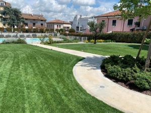ペスキエーラ・デル・ガルダにあるHomingarda - fine holiday apartmentsのプールのある庭を通る歩道