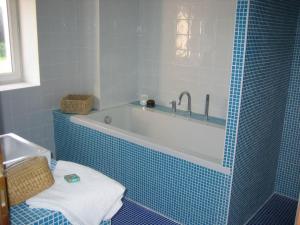 a blue tiled bathroom with a tub and a sink at LA GRANGE in Saint-Prix-lès-Arnay +37 photos