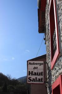 una señal en el lado de un edificio que lee Antlez nuestro salat de hora en Auberge du Haut Salat, en Seix