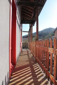 einen hölzernen Gehweg mit einer roten Tür an einem Gebäude in der Unterkunft Auberge du Haut Salat in Seix