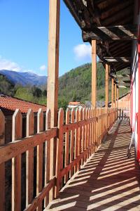 a wooden fence on a building with mountains in the background at Auberge du Haut Salat in Seix