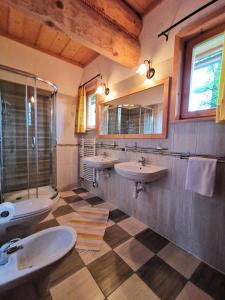 a bathroom with two sinks and two mirrors at Galicówka na Górce in Biały Dunajec