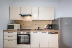 a kitchen with white cabinets and a stainless steel refrigerator at Apartments Drenje 294 in Drenje