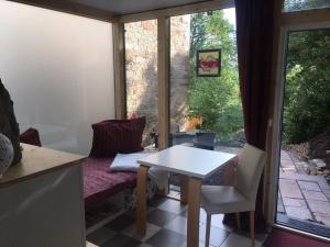 a table and chair in a room with a window at Ferienwohnungen Blume am Schloßberg in Bad Berka