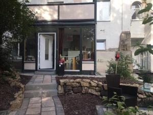 a house with a glass door and a stone wall at Ferienwohnungen Blume am Schloßberg in Bad Berka