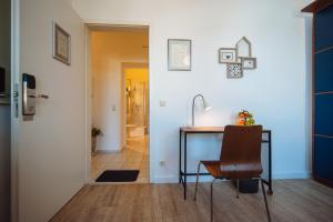 Habitación con escritorio, lavabo y pasillo. en Apartmenthaus Kaiser Friedrich, en Potsdam