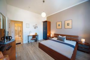 a bedroom with a bed and a desk and a bathroom at Apartmenthaus Kaiser Friedrich in Potsdam