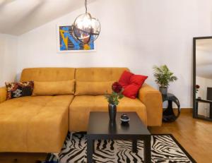 a living room with a brown couch and a table at Adria Apartments and Rooms in Dubrovnik