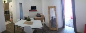 a living room with a white table and a mirror at Appartamenti del Comandante in Santa Marina Salina