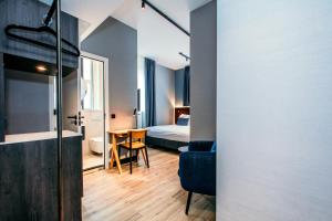 een hotelkamer met een slaapkamer, een bed en een tafel bij Amsterdam Beach Hotel in Zandvoort