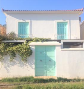 een wit huis met een groene deur bij La Casetta in Galaxidhion