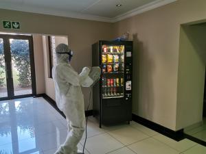 a person in a white suit standing in front of a vending machine at Eagle Nest Luxury Accommodation in Roodepoort