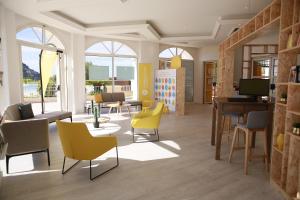 a living room with yellow chairs and a table at Residence Le Hameau Cap Esterel - maeva Home in Agay - Saint Raphael