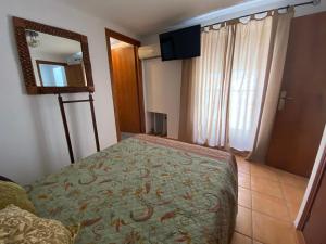 a small bedroom with a bed and a mirror at APARTAMENTO RURAL CASA MONTE in Cazalla de la Sierra +16 photos