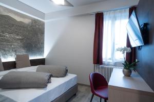1 Schlafzimmer mit 2 Betten, einem Schreibtisch und einem Fenster in der Unterkunft Locanda al Crap in Tresivio