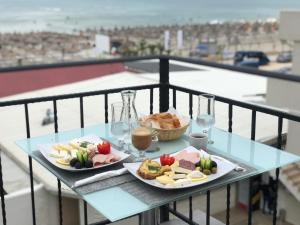 a table with two plates of food on a balcony at SaloS Beach Resort in Mamaia Sat/Năvodari