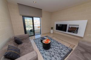 sala de estar con sofá y TV en Vittoriosa' Seafront 2 Bed Highly Furnished Apartment, en Birgu