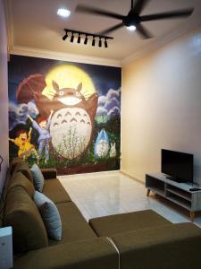 ein Wohnzimmer mit einem Sofa und einem Gemälde an der Wand in der Unterkunft 12 pax Bidor Totoro House in Bidur